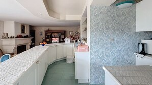 Eine moderne Küche mit weißen Schränken, einer gewölbten Arbeitsplatte und einer gemusterten Spritzschutzleiste.