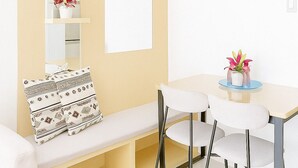Ein modernes Wohnzimmer mit einem weißen Sofa, einem Couchtisch und einem Bücherregal mit Dekorationselementen.