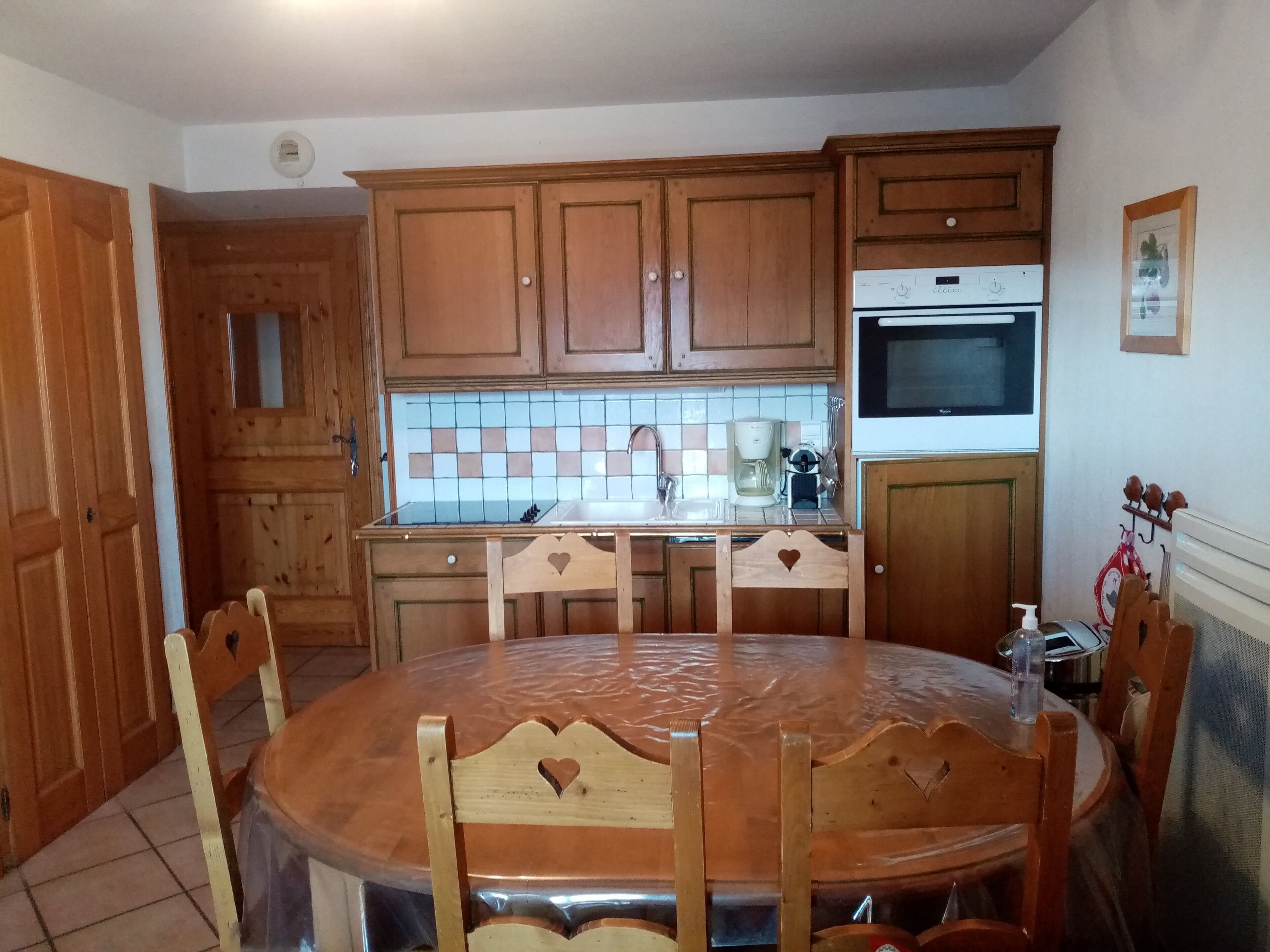 A kitchen with wooden cabinets, a tiled backsplash, a coffee maker, and a microwave.