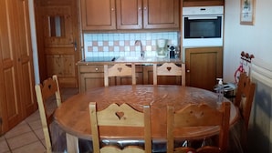 A kitchen with wooden cabinets, a tiled backsplash, a coffee maker, and a microwave. - APARTMENT FACING MONT BLANC AND BEAUFORTAIN VALLEY (Villard-sur-Doron)