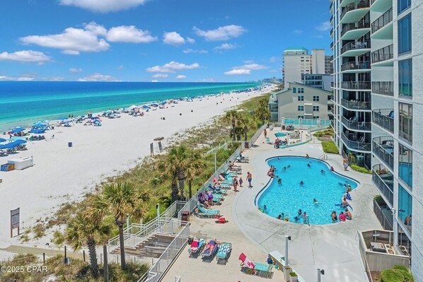 Ein Resort mit Strand, Pool und einem Hochhaus.