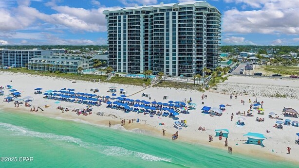Ein Hochhaus-Hotel mit mehreren Balkonen mit Blick auf einen Strand.
