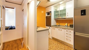 A compact kitchen with a washing machine, microwave, and refrigerator. - Tapioles: Nice apartment with balcony in Poble Sec (Poble Sec)