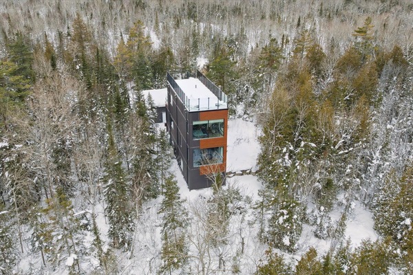 A modern treetop retreat perched high in the forest, offering privacy, design-forward comfort, and a peaceful Bruce Peninsula escape in every season.