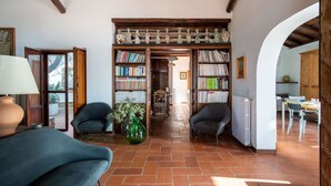 Un salon chaleureux avec une cheminée, une bibliothèque et un coin repas.