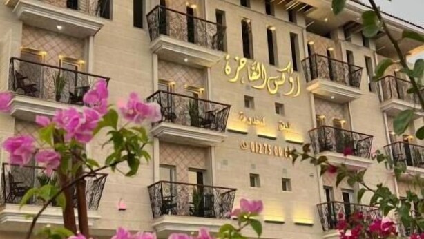 A multi-story hotel with balconies and a sign in a foreign language. - Rox luxury Hotel (Taif)
