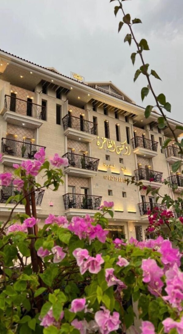 A multi-story hotel with balconies and a sign in a foreign script.