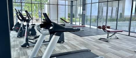 A gym with treadmills, stationary bikes, and a rowing machine.