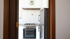 A kitchen with a gas stove, oven, and refrigerator. - SE183 - Senigallia, comfortable three-room apartment 100 meters from the sea (Senigallia)