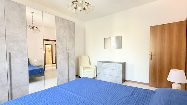 A bedroom with a large bed, a wardrobe, a desk, a chair, and a door. - SE183 - Senigallia, comfortable three-room apartment 100 meters from the sea (Senigallia)