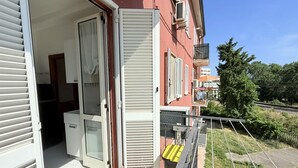 An open balcony with a sliding door, a small table, and a chair. - SE183 - Senigallia, comfortable three-room apartment 100 meters from the sea (Senigallia)