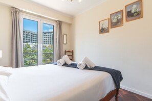 A hotel room with a bed, a view through a sliding door, and three framed pictures on the wall. - Forum Delights Apartment by Atlantic Holiday (Funchal)