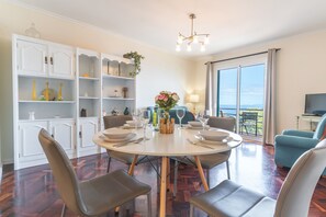 A dining area with a round table, chairs, and a view of the outdoors. - Forum Delights Apartment by Atlantic Holiday (Funchal)