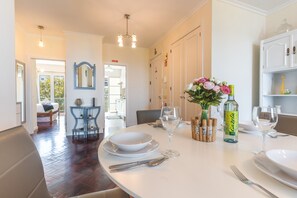 A dining area with a table set for two, a mirror, and a view into another room. - Forum Delights Apartment by Atlantic Holiday (Funchal)