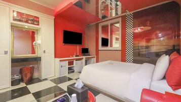 Una habitación de hotel con una cama grande, televisión, escritorio y baño.