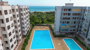 A rooftop swimming pool with a view of the beach and ocean. - Residence Belvedere (Lido Adriano)