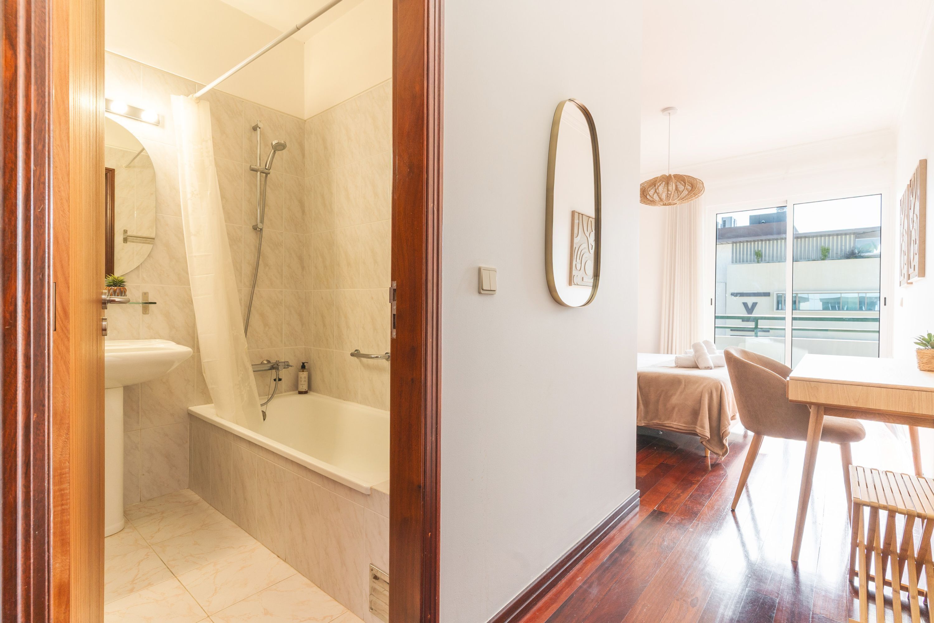 A modern bathroom with a bathtub, shower, and a toilet.