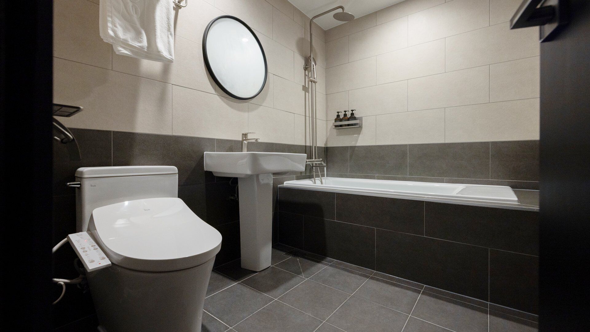 Ein modernes Badezimmer mit Toilette, Waschbecken und Badewanne.
