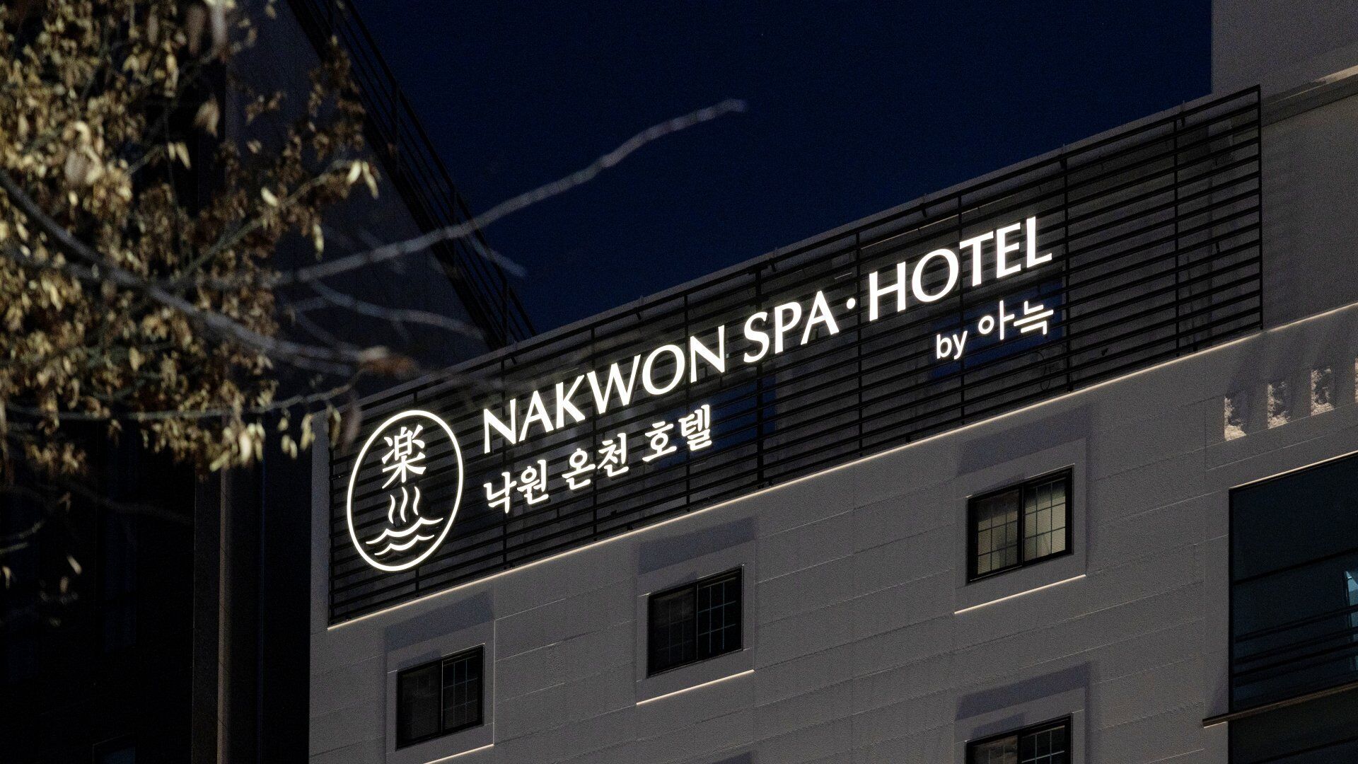 A building with a sign reading "NAKWON SPA HOTEL by 아웃".