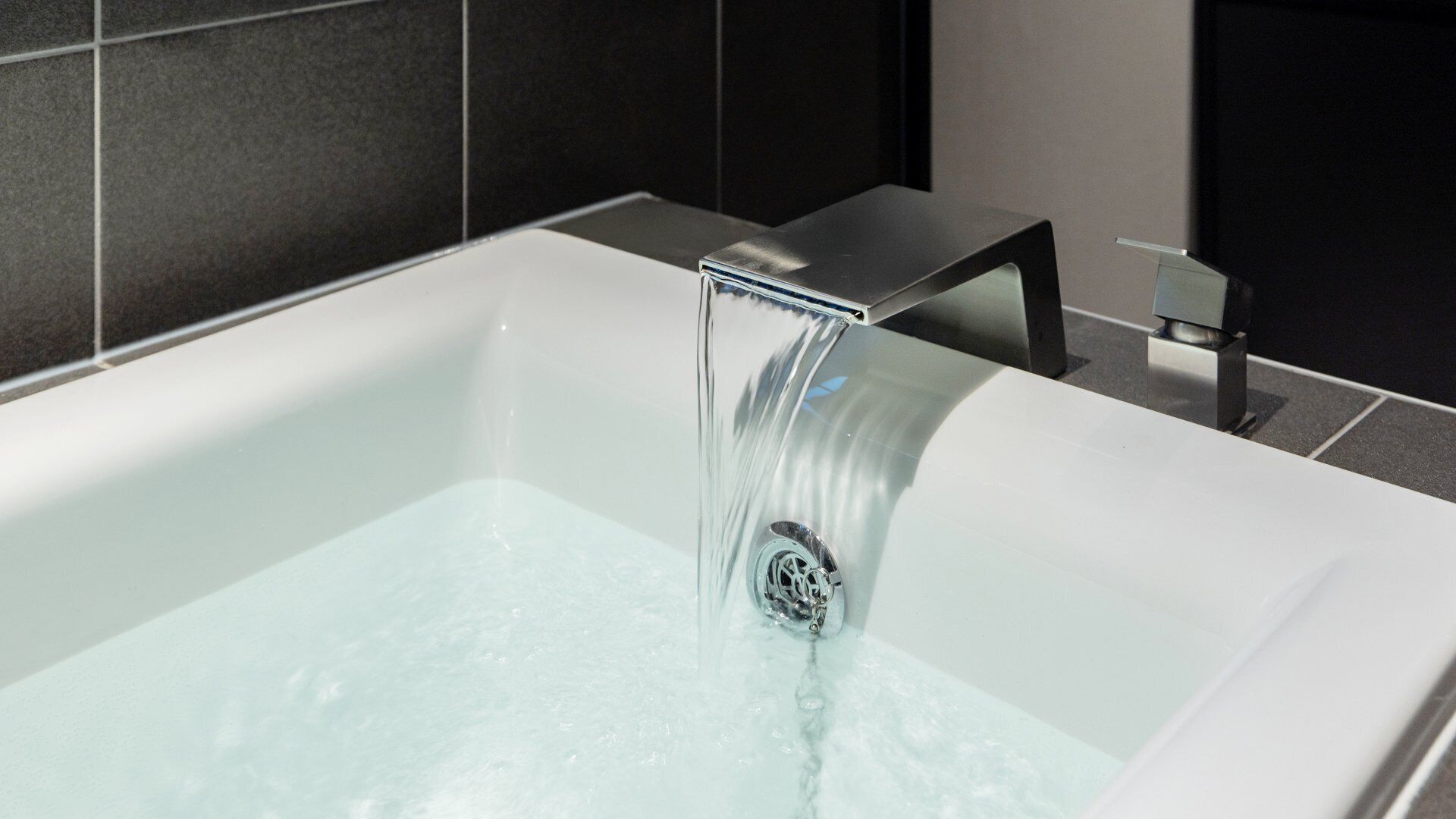 Un baño moderno con bañera, grifo cromado y cabina de ducha de cristal.