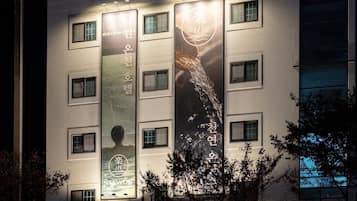 Een gebouw met veel ramen en banners waarop tekst en een logo staan.