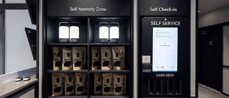 Quiosco de autoservicio con terminal de tarjetas, registro automático y zona de servicios propia.