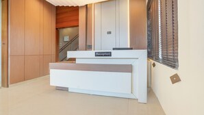 A reception desk with a sign, wooden paneling, and a staircase in the background. - The Byke Boutique Tejjora (Lucknow)