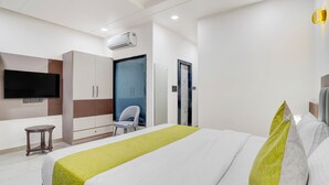 A modern hotel room with a large bed, a flat-screen TV, a wardrobe, a desk, and a chair. - The Byke Boutique Tejjora (Lucknow)