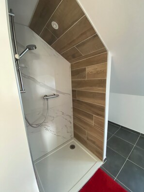 Een douche, een haardroger, handdoeken, toiletpapier