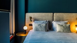 Un letto rifatto con due cuscini e una lampada da comodino.