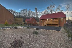 A rustic cabin-style building with a red roof, a wooden exterior, and a gravel driveway. - 2BR 2BA Lakefront Gem – Decks, Docks & Sunsets (Johnson City)