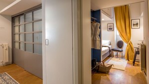 Et moderne soveværelse med en skydedør, en seng, en stol og en radiator.