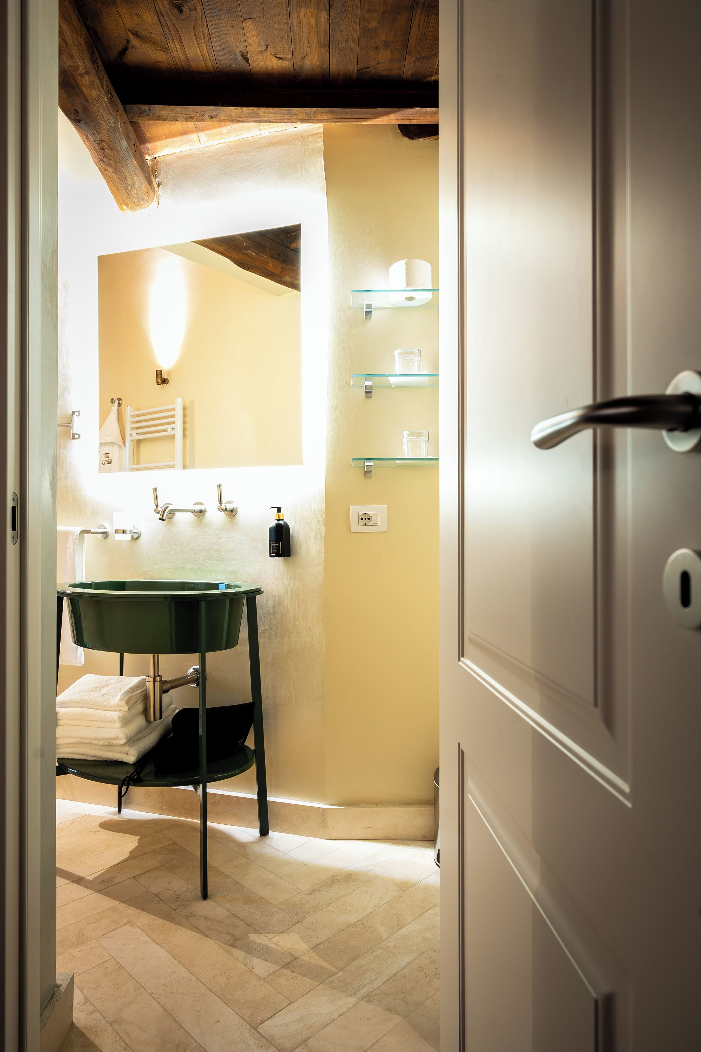 Une salle de bain avec un lavabo vert, un porte-serviettes et un miroir.