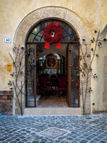 Una entrada con un arco de piedra, un adorno rojo y un letrero con el número 40.