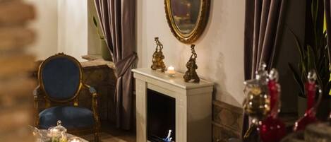 Un comedor con chimenea, un espejo y una mesa dispuesta con velas y adornos.