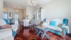 Ein geräumiges Wohnzimmer mit Essbereich, einer Couch und einem Couchtisch.