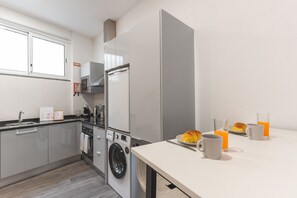 A modern kitchen with a washing machine, a microwave, and a coffee maker. - Santa Cruz Studio 3 by Atlantic Holiday (Santa Cruz)