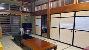 A traditional Japanese room with tatami flooring, a low wooden table, a television, and sliding doors. - Echigo-Tsumari Art Triennale near the ski resort. (Tokamachi)