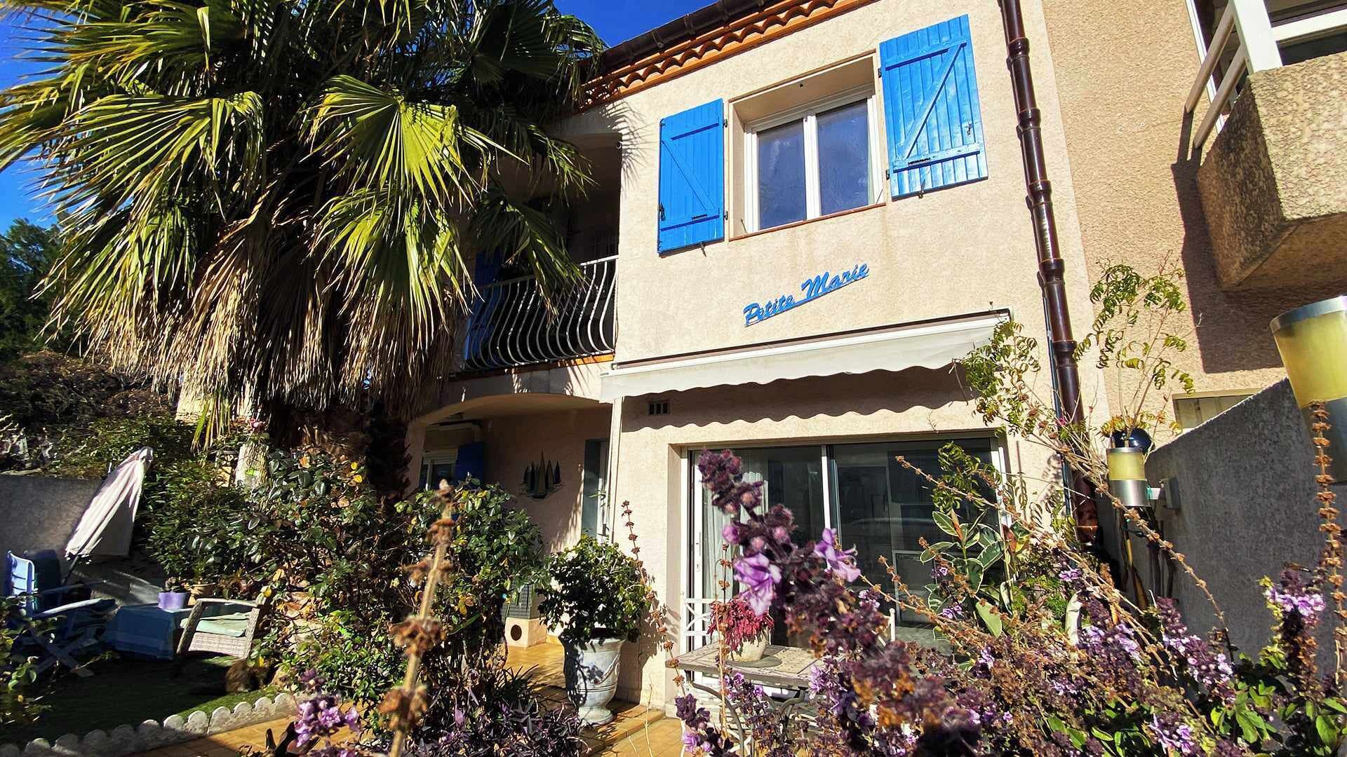 A building with a sign reading "Biste Marie" and a balcony with blue shutters.