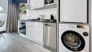 Una cocina moderna equipada con microondas, horno, lavavajillas y lavadora.