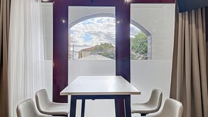 Una habitación con un ventanal amplio, una mesa blanca y dos sillas.