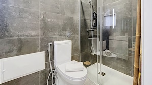 Ein modernes Badezimmer mit einer Duschkabine, einer Toilette und einem Waschbecken.