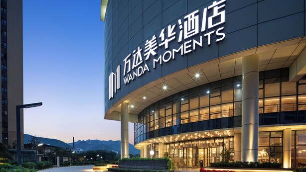A modern hotel entrance with a large sign reading "Wanda Moments". - Wanda Moments Zibo (Zibo)