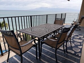 A balcony with a table and chairs, overlooking a body of water. - Oceanfront Whale Watching Sunsets Island Views on Big Lanai (Lahaina)