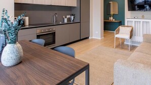 Eine moderne Küche mit Essbereich, einem Sofa und einem Fernseher im Wohnzimmer.