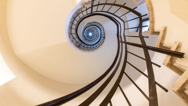 Eine Wendeltreppe mit einer zentralen Säule und Metallgeländern.