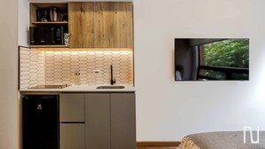 Une cuisine compacte équipée d’un four à micro-ondes, d’une machine à café et d’un lave-vaisselle.