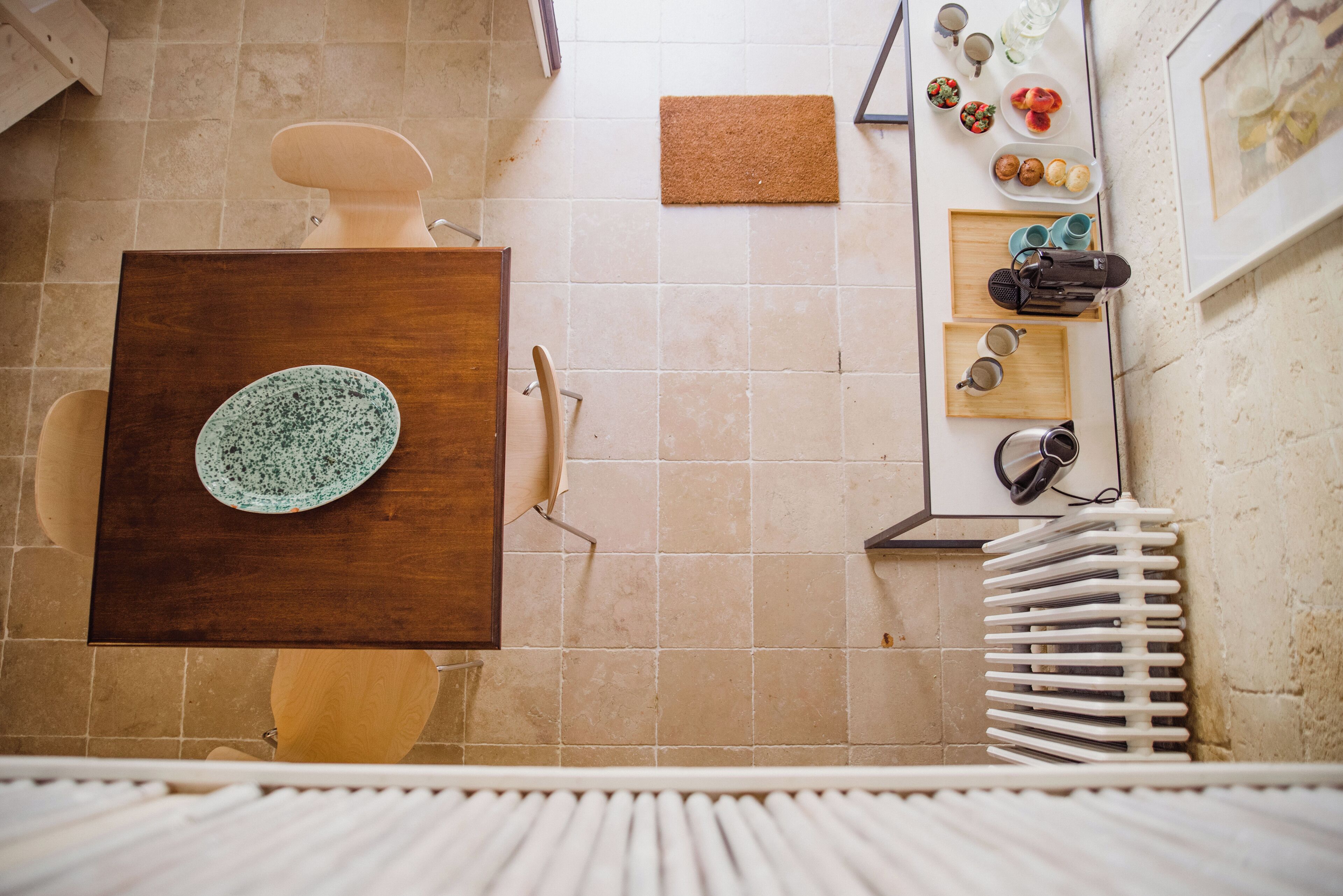 A bathroom with a wooden vanity, a sink, a mirror, and a towel rack.