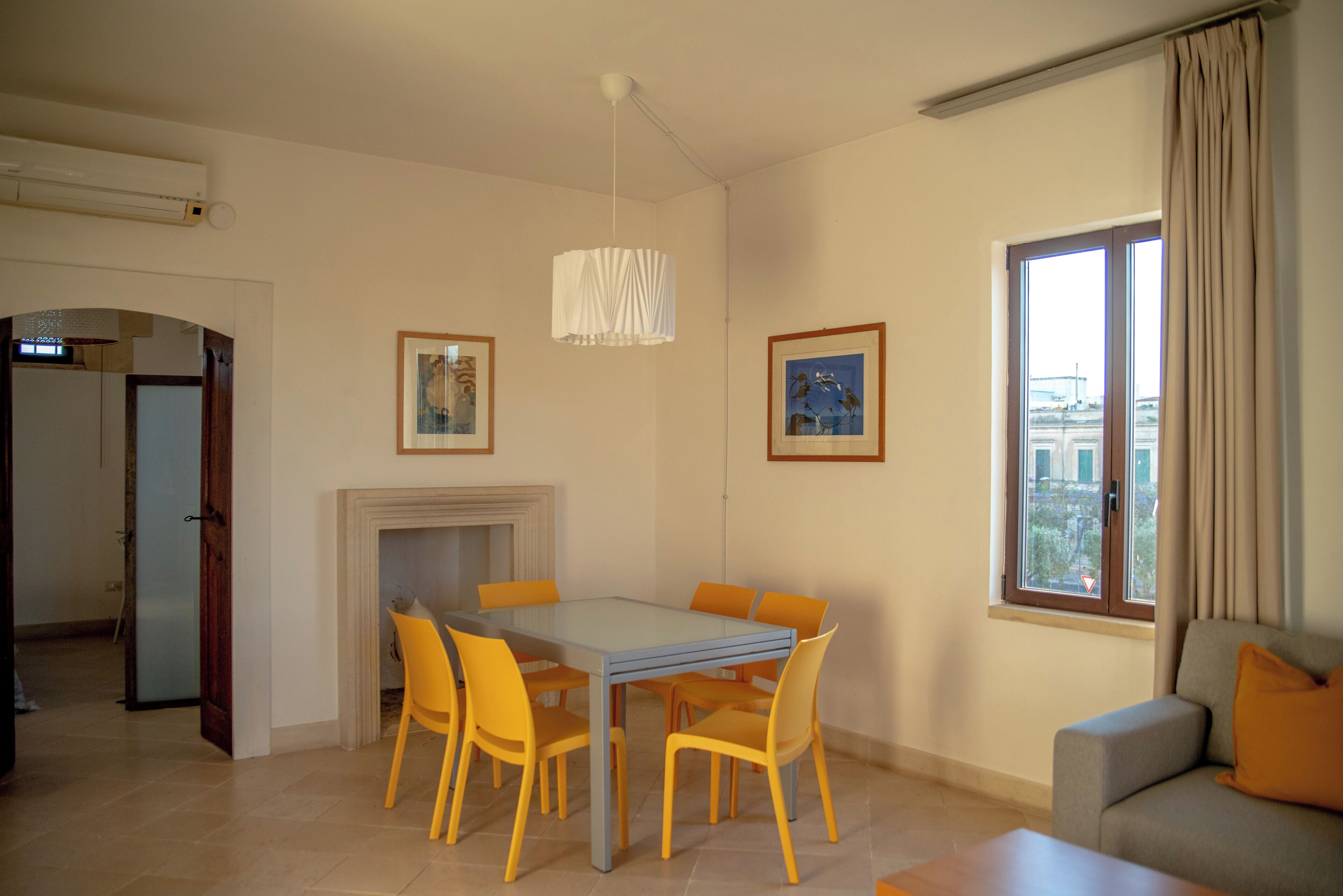 Un área de comedor con una mesa, sillas, una chimenea y un sofá.