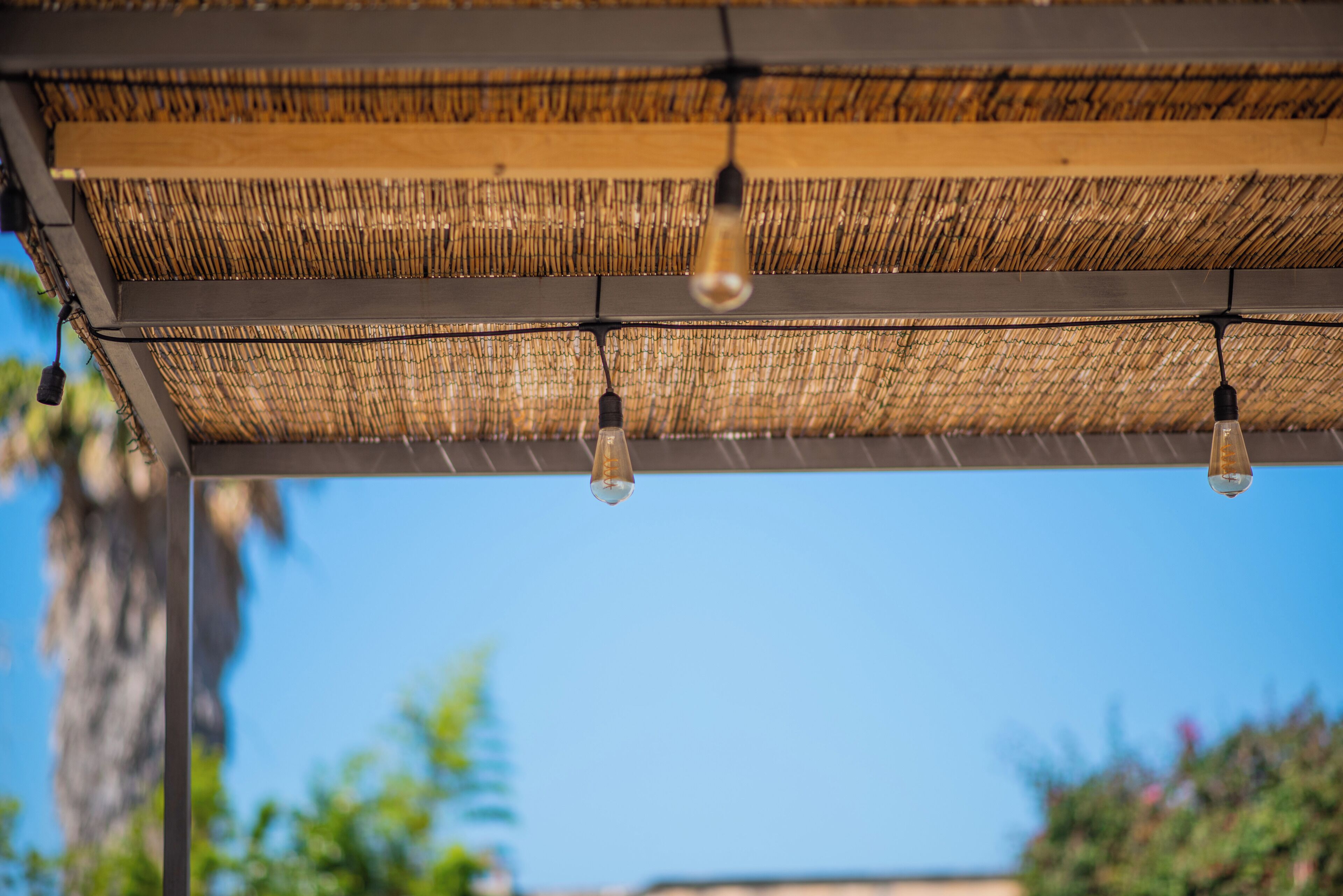 A ceiling with woven material and hanging light bulbs.